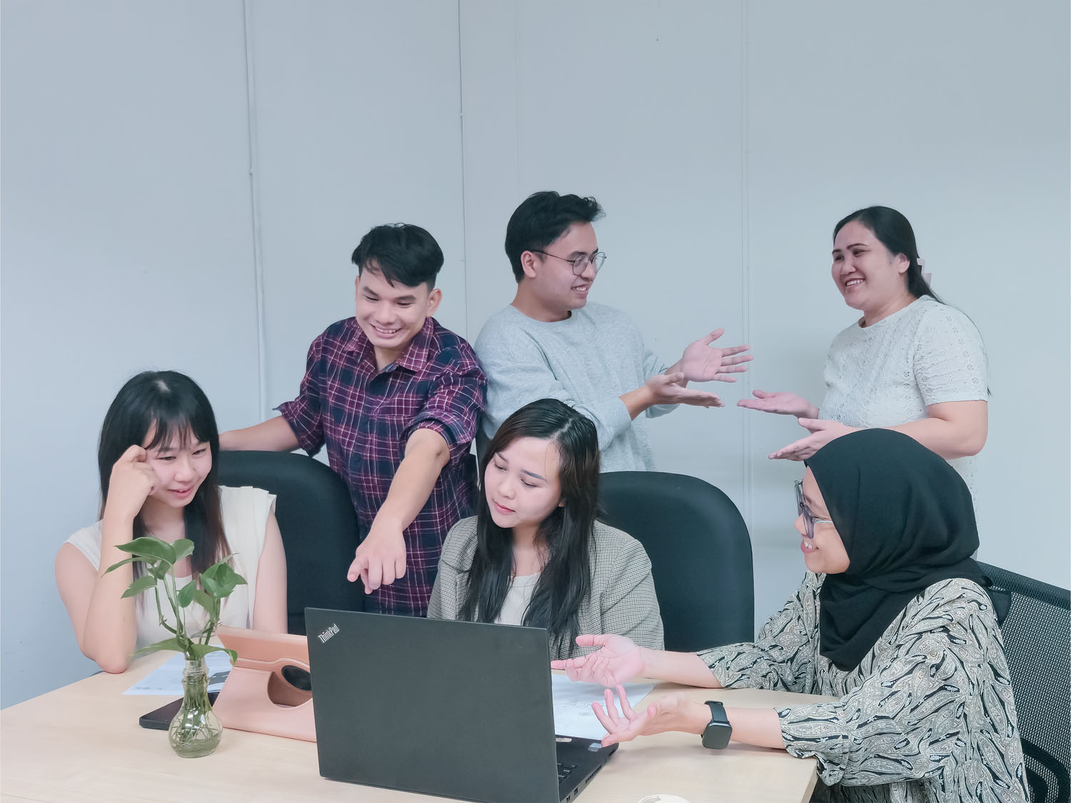 MediaPlus team collaborating around a laptop