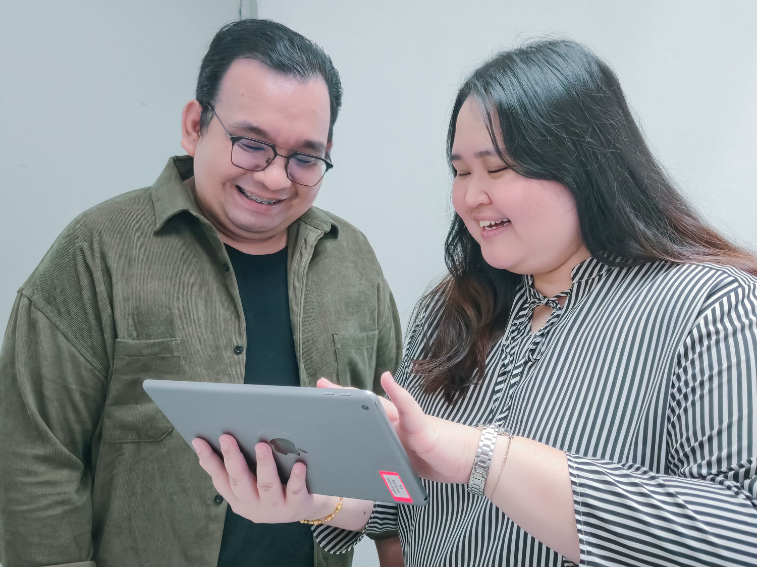 MediaPlus team members discussing information on a tablet